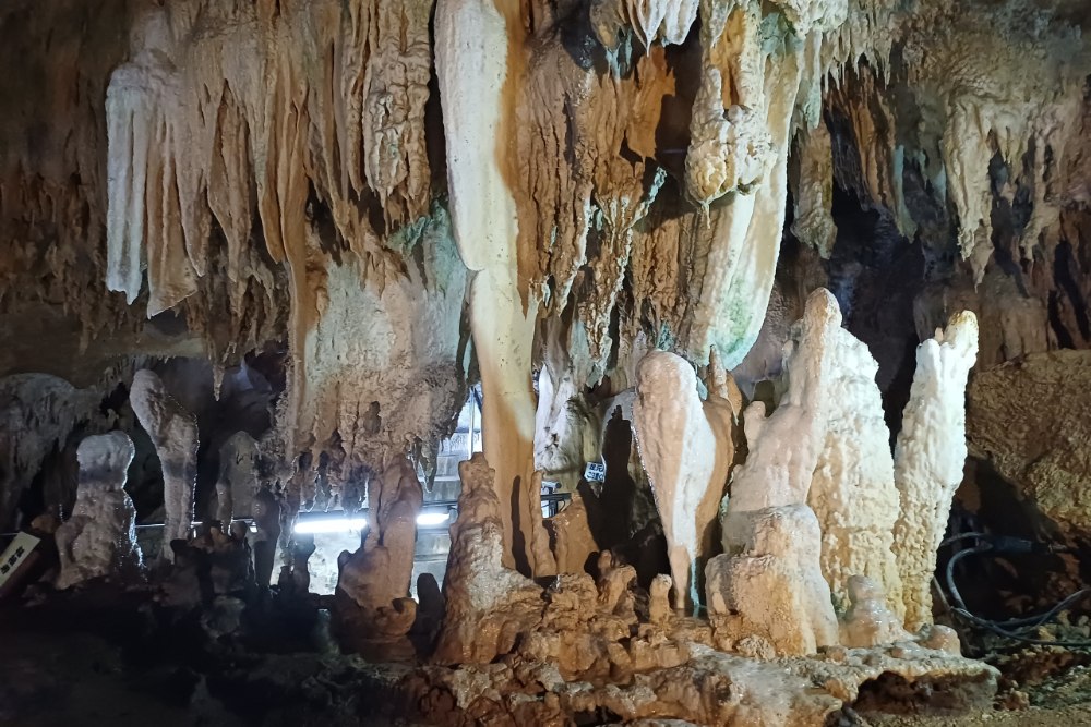 石垣島鐘乳石洞內七彩燈光石柱景觀，洞內全年溫度較為涼爽，是炎熱天氣裡很適合安排的室內景點 。